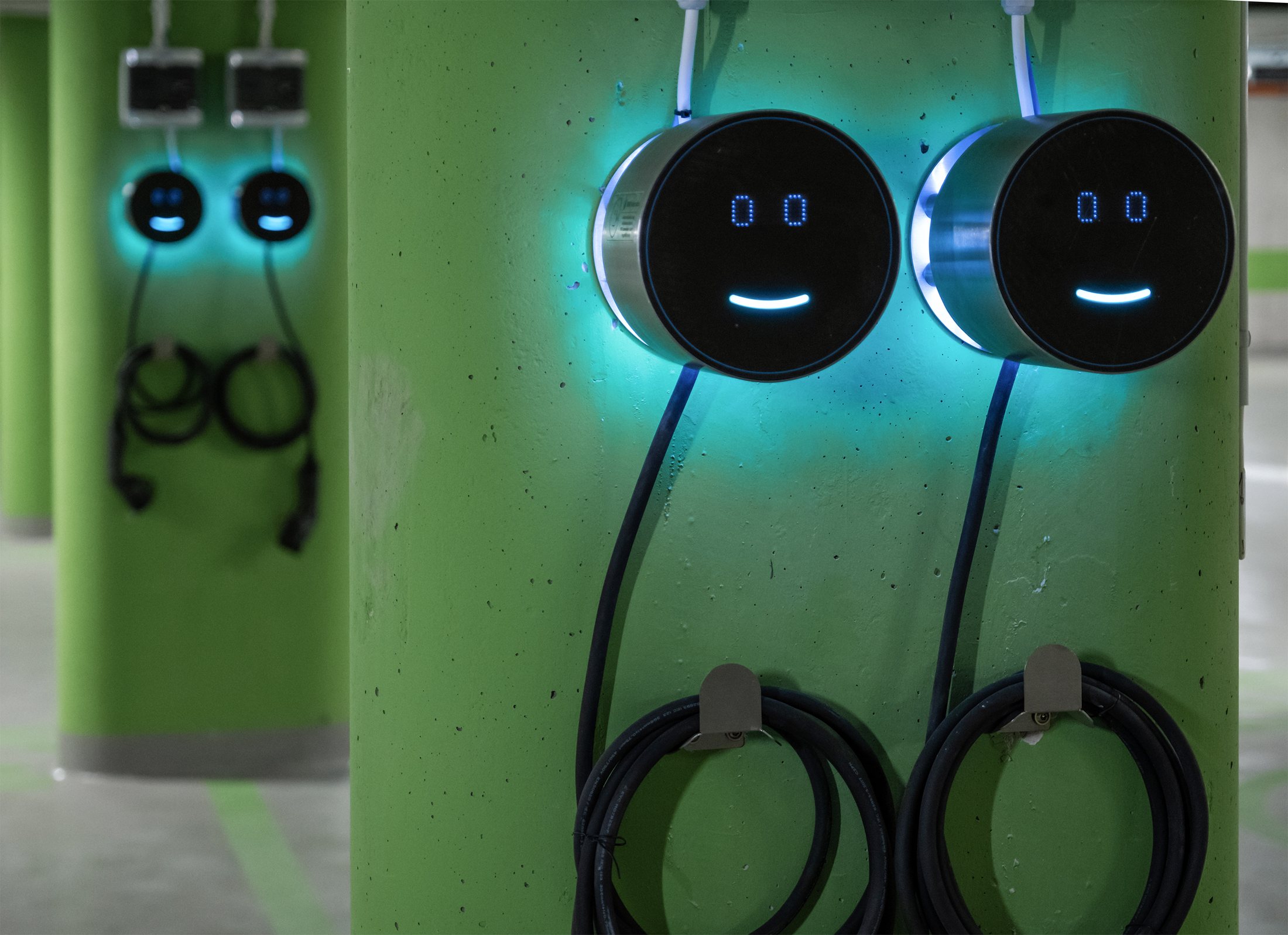 Two Voltie chargers on a green wall